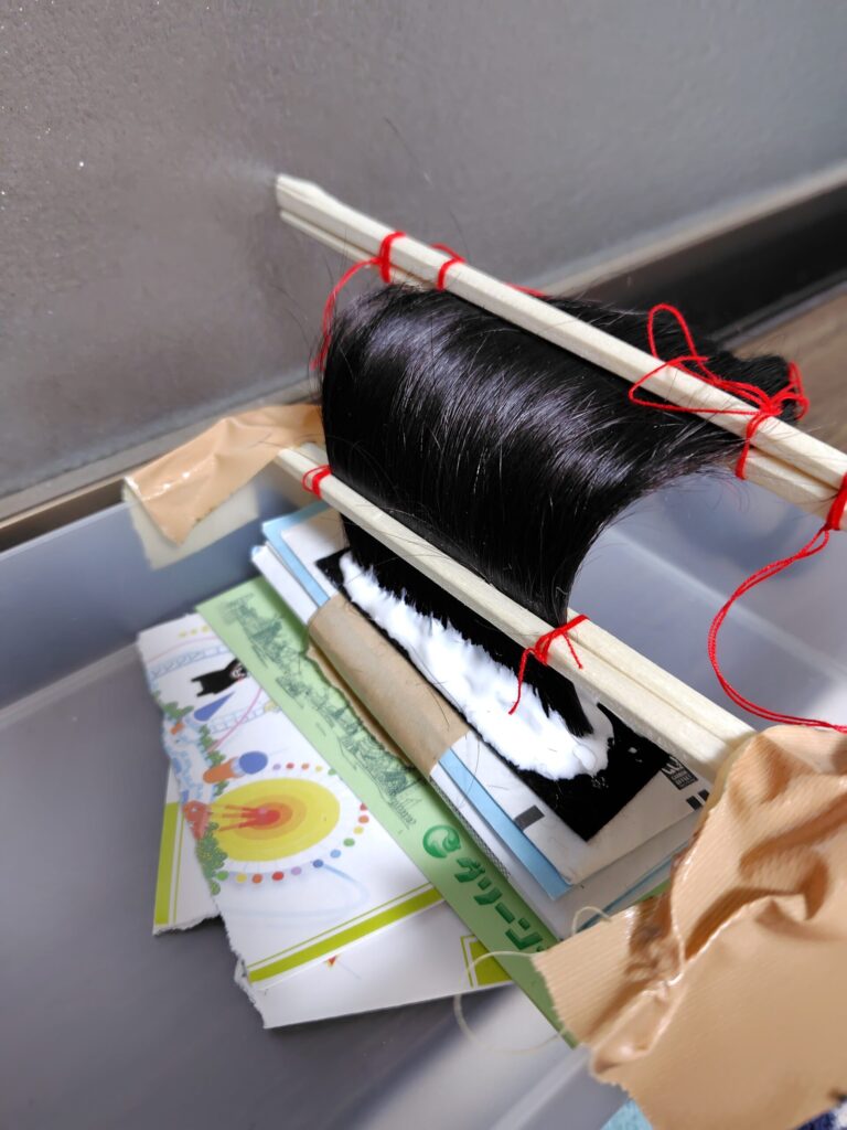 ヅラの作り方2
切った毛をまとめて木工用ボンドで固定します。